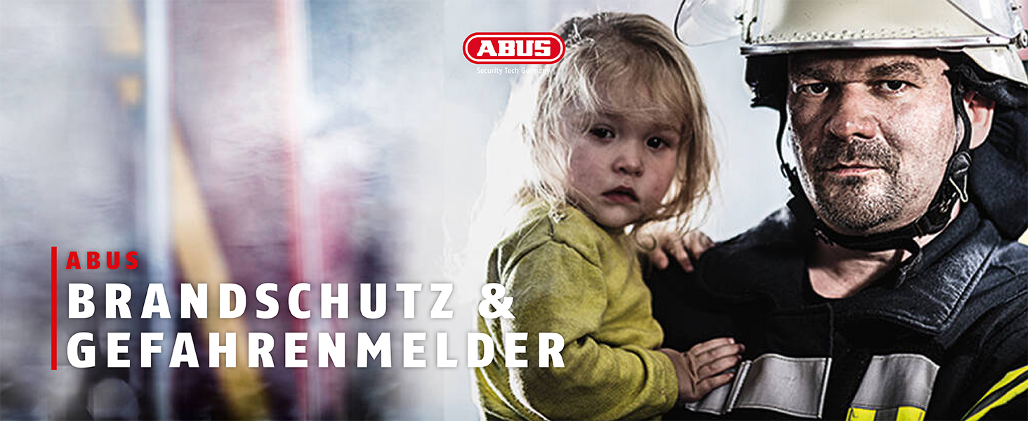 bild zu brandschutz und gefahrenmeldern zeigt einen feuerwehrmann vor rauch mit kind auf dem arm