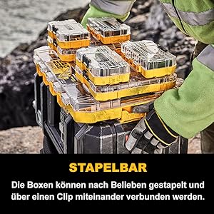 Ein Mann stapelt mehrer Zubehörboxen aufeinander.